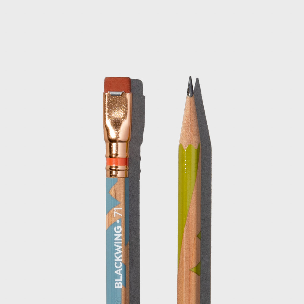 Wooden pencils with green and blue accents displayed on a neutral background.