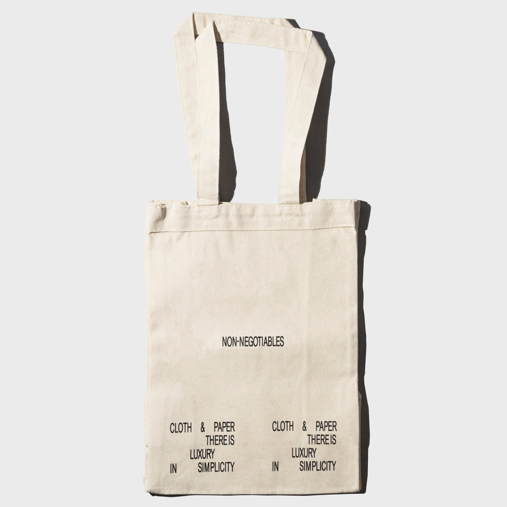 Non Negotiables Tote Bag, Cloth and Paper. Bag displayed on a neutral background.