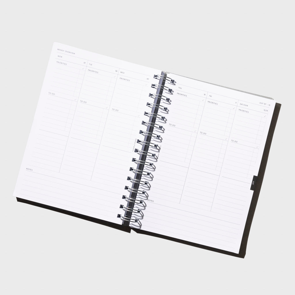 Notebook displayed opened on a neutral background.