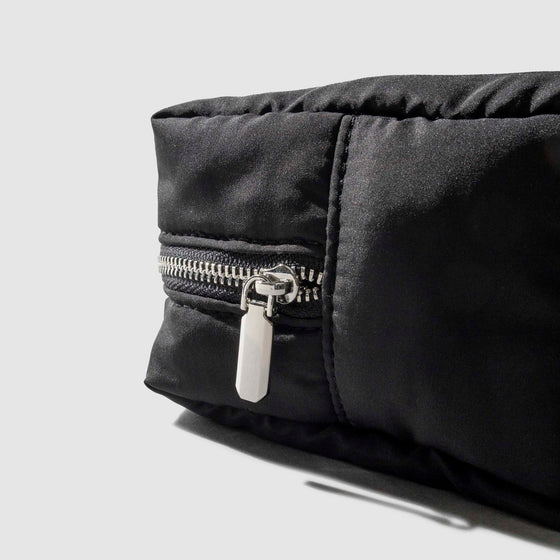 Closeup of silver zipper hardware on quilted pouch.