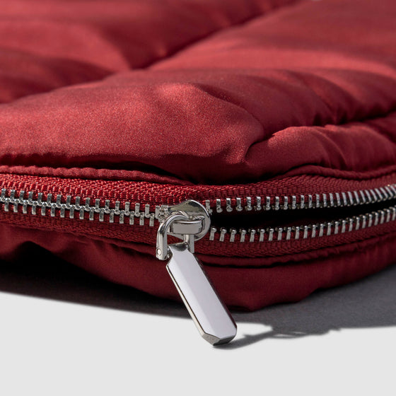 Closeup of silver zipper hardware on pouch. Color shown is Merlot.