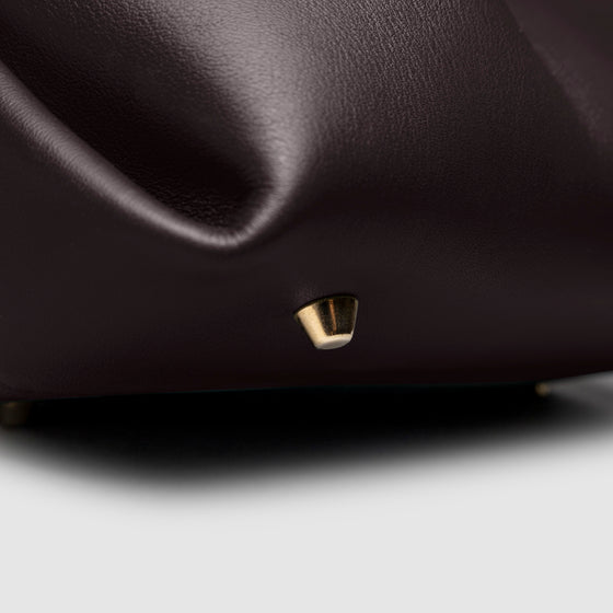 Closeup of the gold feet on the bottom of the bag. Color shown is Madrid.