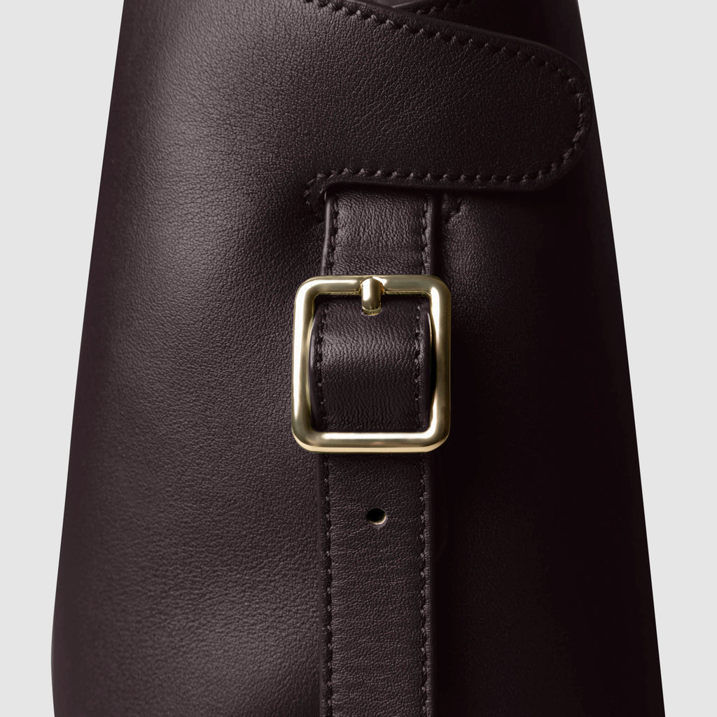 Side view of bag showcasing its gold hardware and adjustable leather strap. Color shown is Madrid.