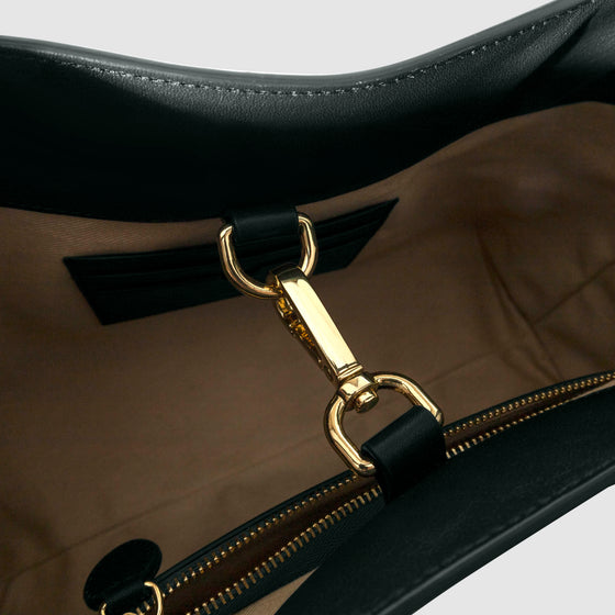 Top down view of bag showcasing its gold hardware. It secures the bag shut. Color shown is Salamanca.