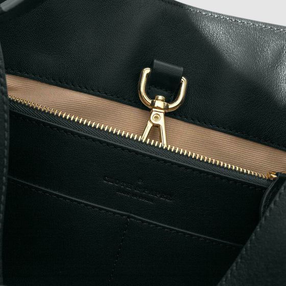 Top down view of bag showcasing its gold hardware. It secures the bag shut. Color shown is Salamanca.