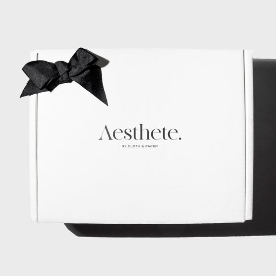 Aesthete Mystery Box, Cloth and Paper. Aesthete box adorned with a black bow displayed on a neutral background.