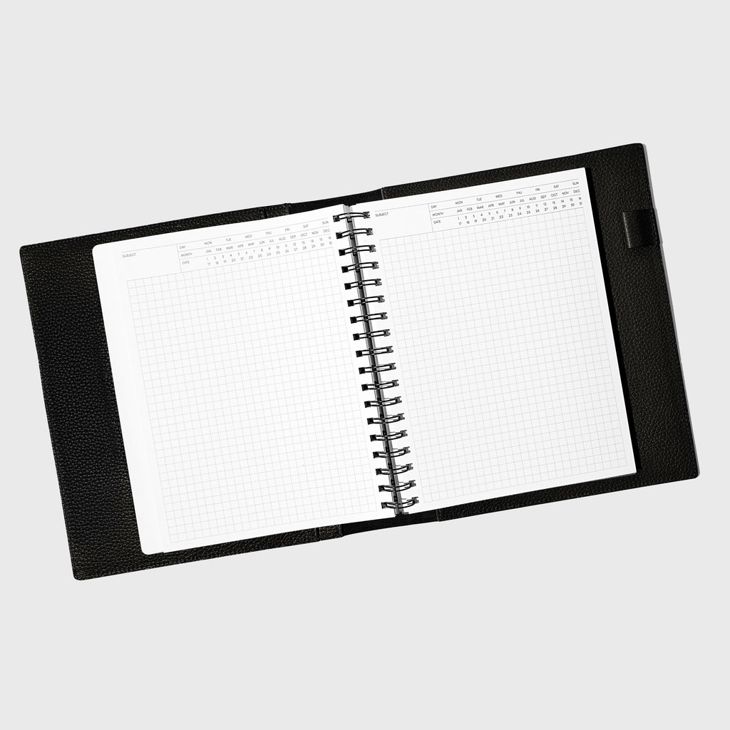 Notebook spread open inside a black leather agenda. Design shown is executive notes.