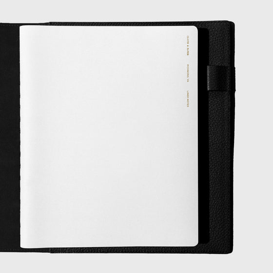 Notebook shown closed inside a black leather agenda. Color shown is Ash.