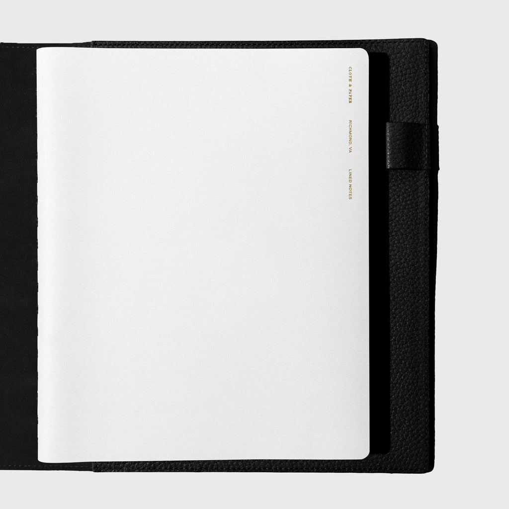 Notebook shown closed inside a black leather agenda. Color shown is Ash.