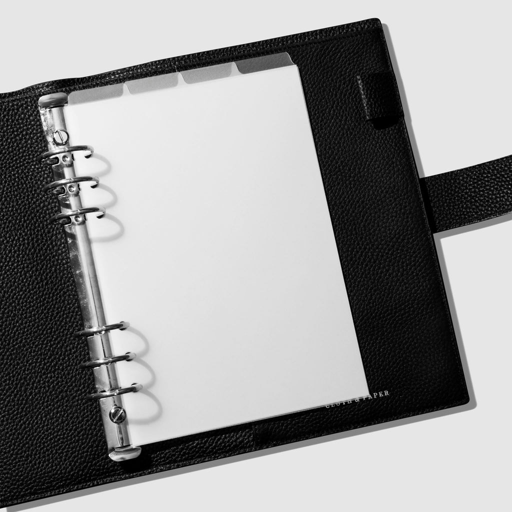 Dividers in use inside a black leather agenda.