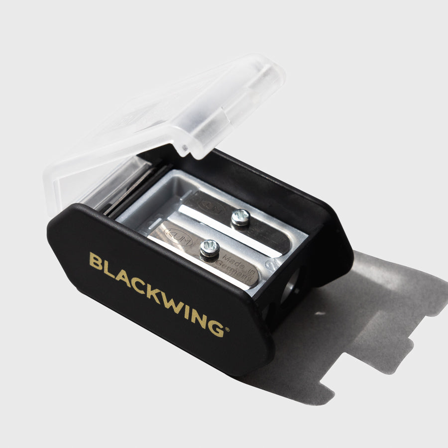 The image shows a close-up of the blackwing long point pencil sharpener showing the blades and the frosted cover.