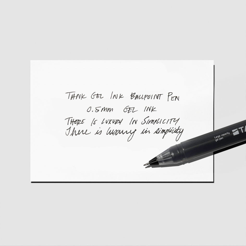 Writing sample displayed with pen on a neutral background.