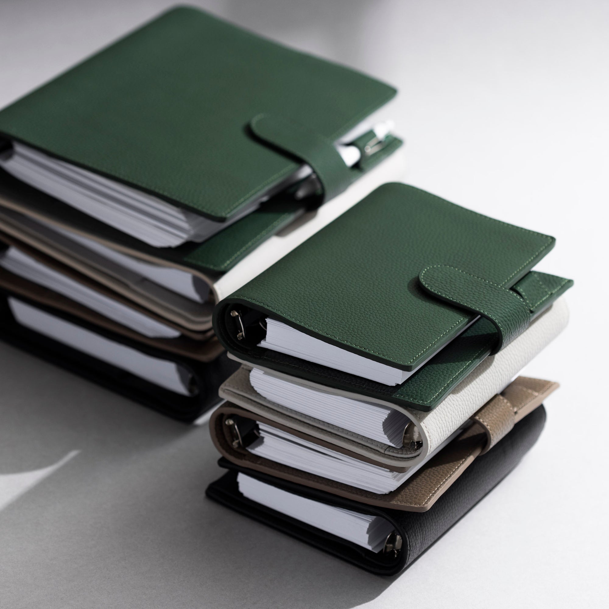 A stack of foundations leather planner arranged on top of a white background