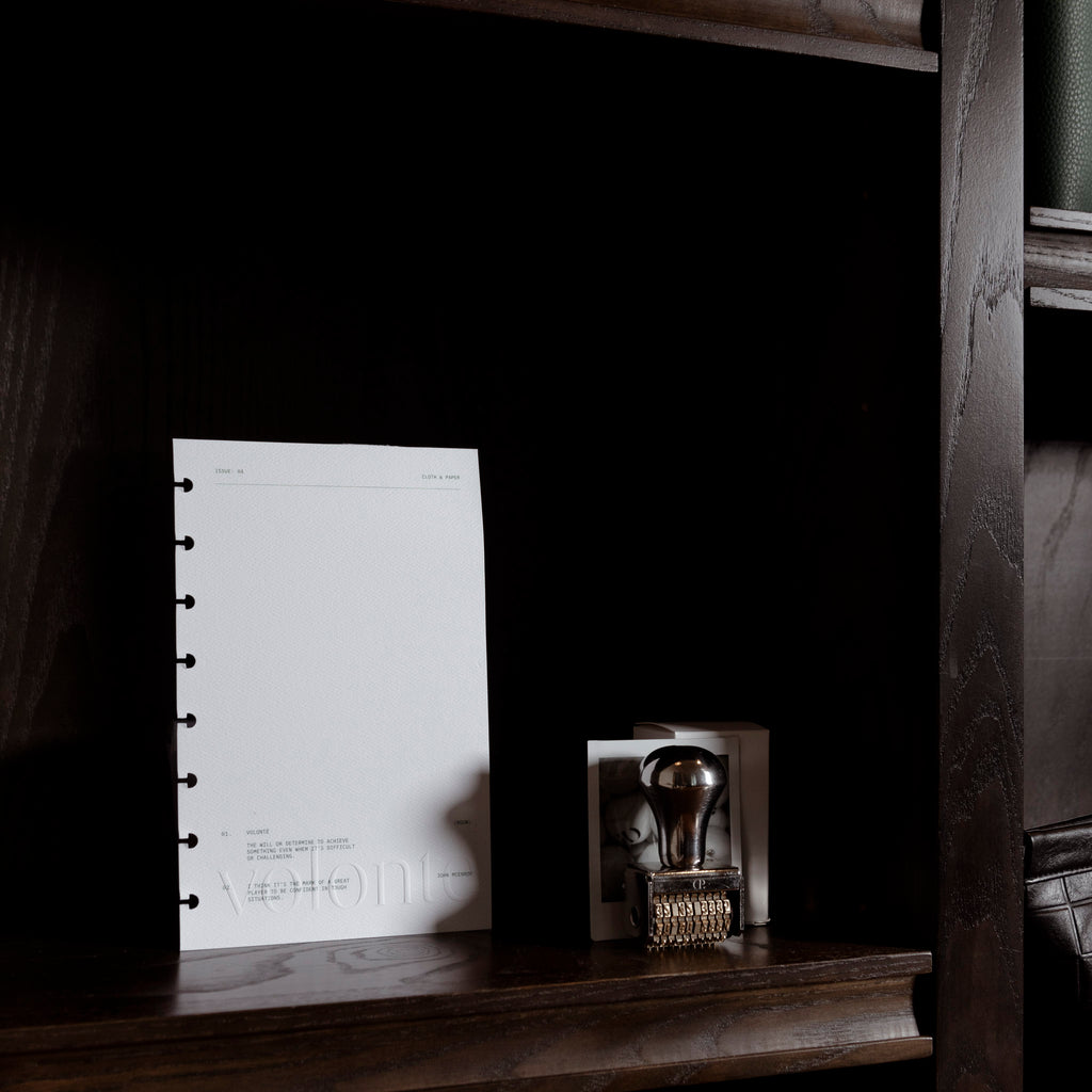 Dashboard displayed inside a dark brown bookshelf. A Cloth and Paper date stamp is shown next to it.