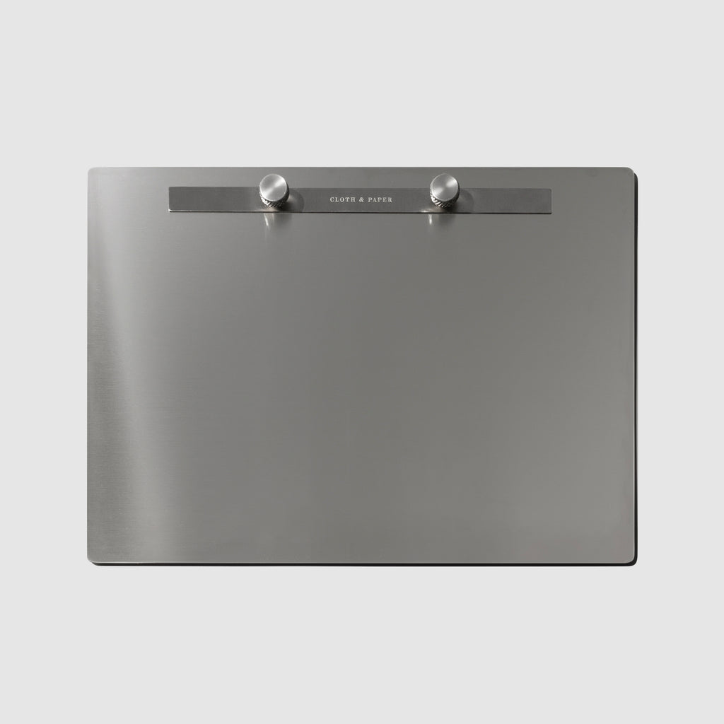 Modern Bound Notepad board, which is stainless steel metal, resting on a light gray background without any inserts