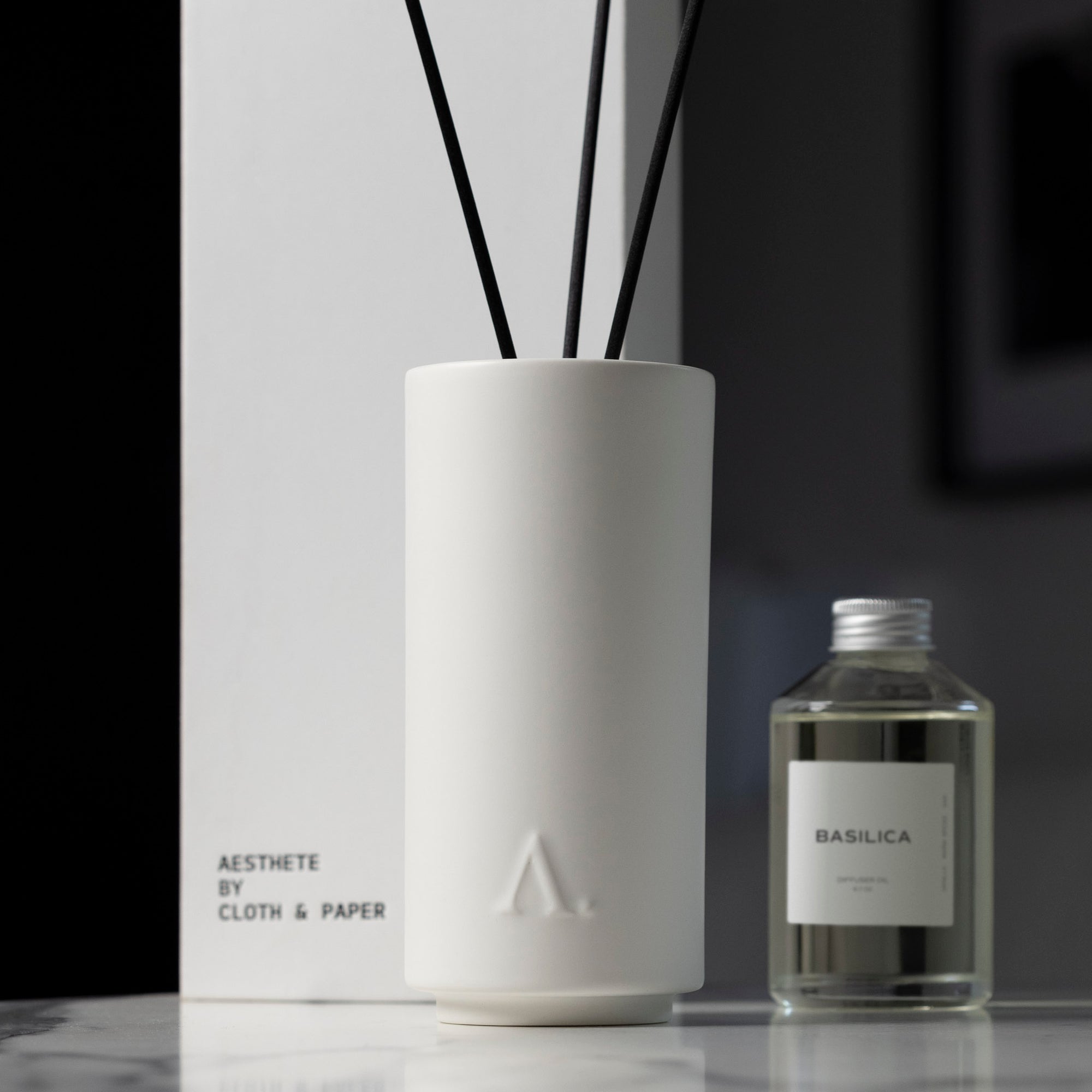 The Basilica Diffuser with Aesthete logo mark sitting next to a bottle Basilica Diffuser Oil.