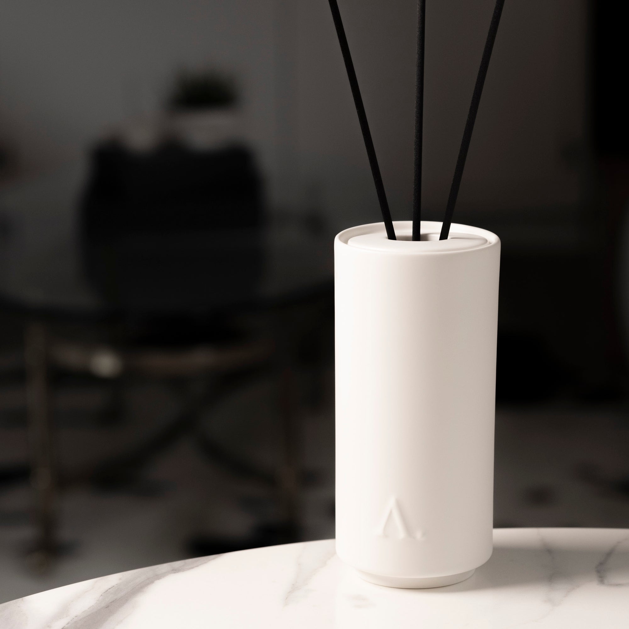 The Basilica Diffuser with Aesthete logo mark sitting on a marble table.