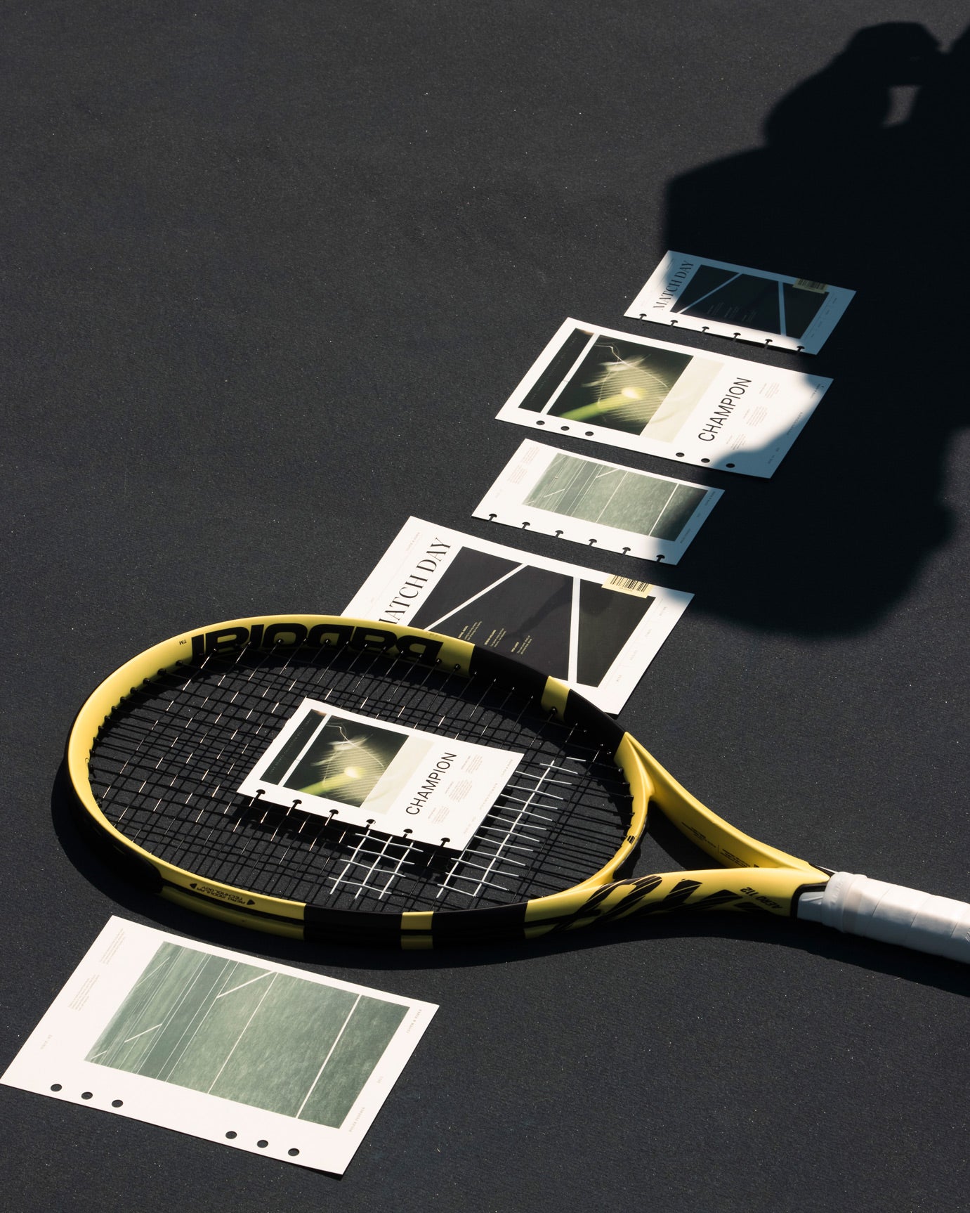 Examples of the Luxe Sports Planner Dashboards are laying on a tennis court with a tennis racket.