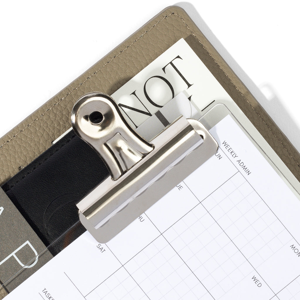 Small clip in use inside a fossil leather planner.