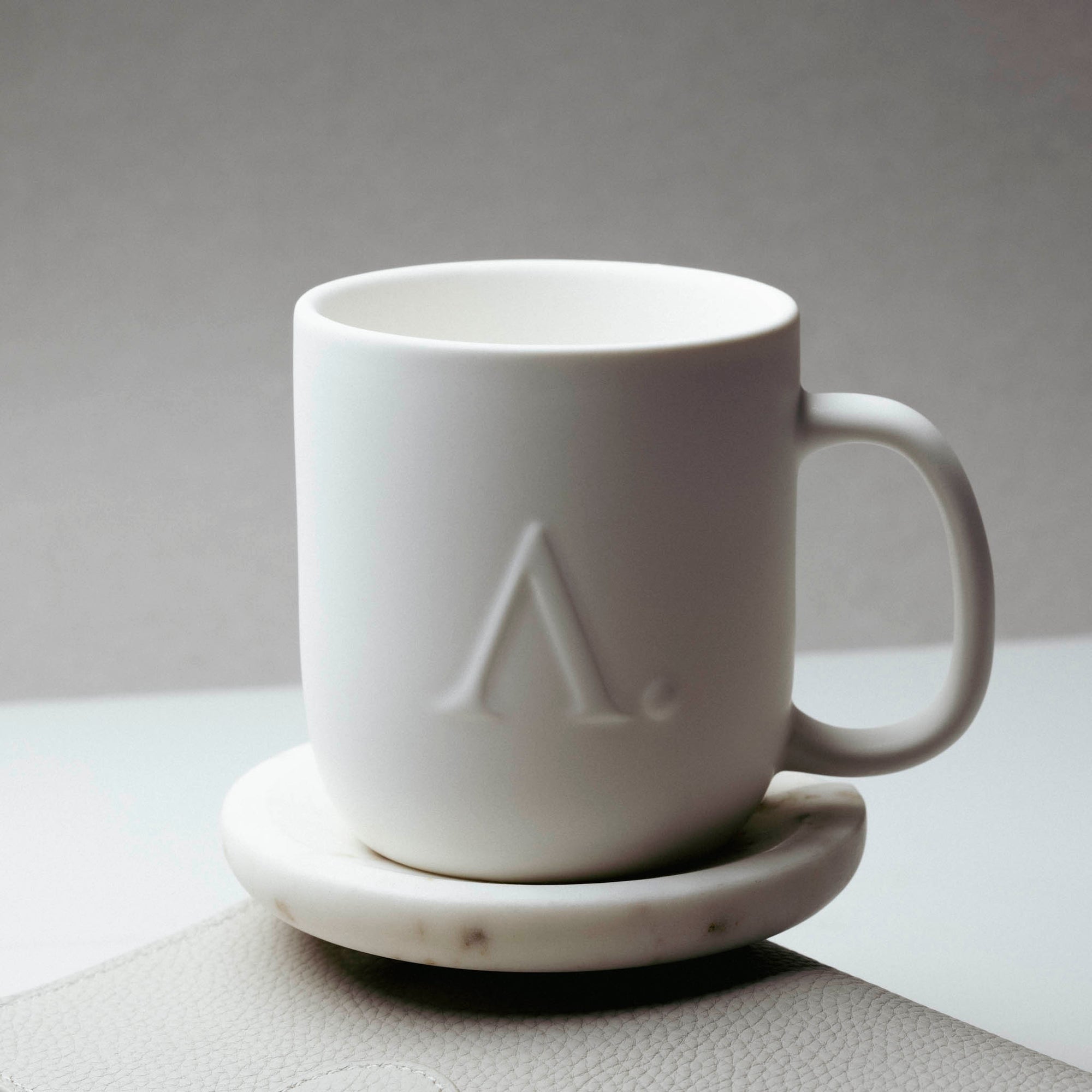 A white ceramic coffee mug with the Aesthete mark.