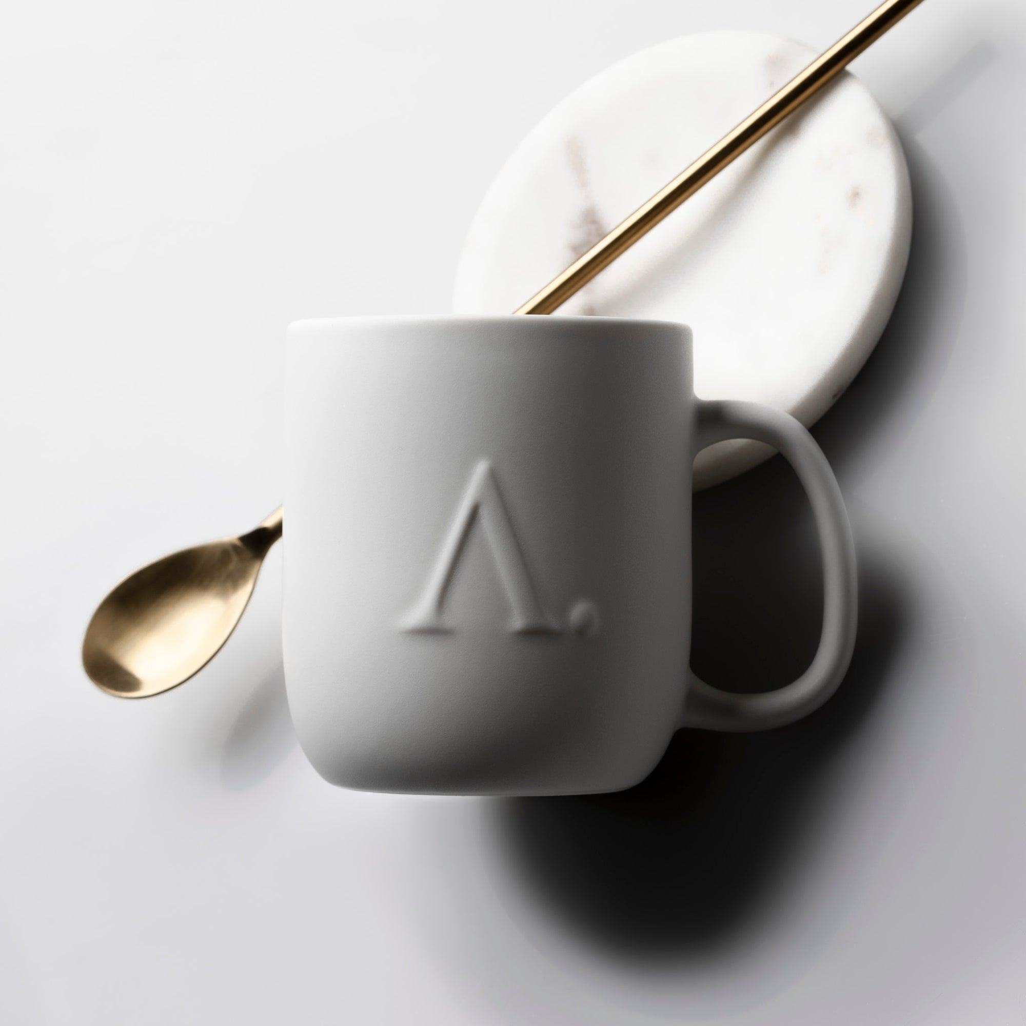 A white ceramic coffee mug with the Aesthete mark.