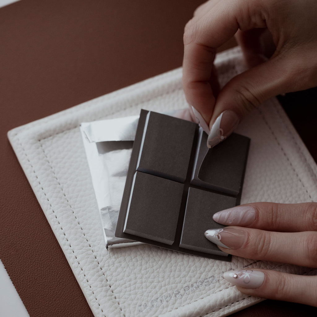 A hand is peeling a Chocolate Page Flag from the set to use.