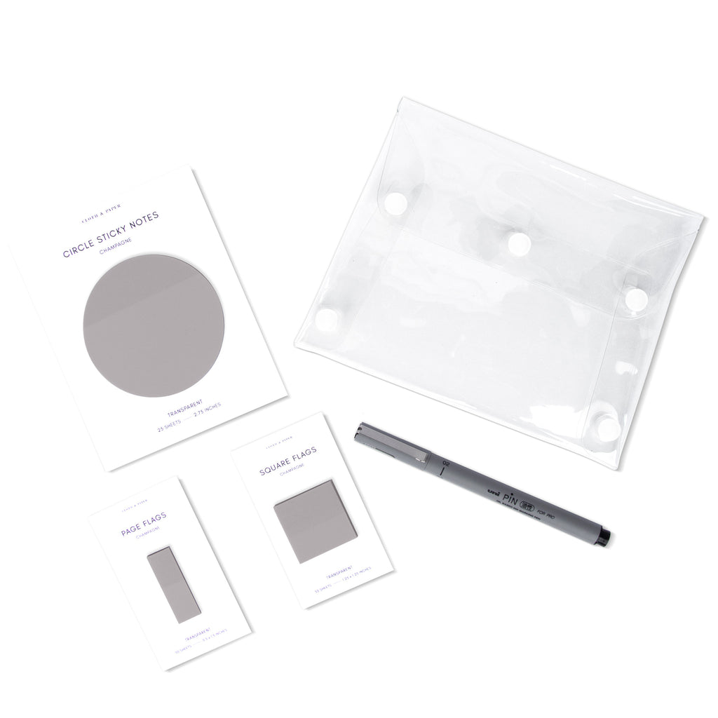 Matching set of circle sticky notes, page flags, and square page flags positioned next to a Uni Pin Marking Pen and Essentials Clear pouch. Sticky note color is Champagne.
