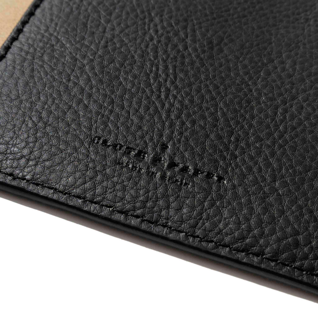 Closeup of mesa black folio's textured vegan leather and stamped Cloth and Paper logo.