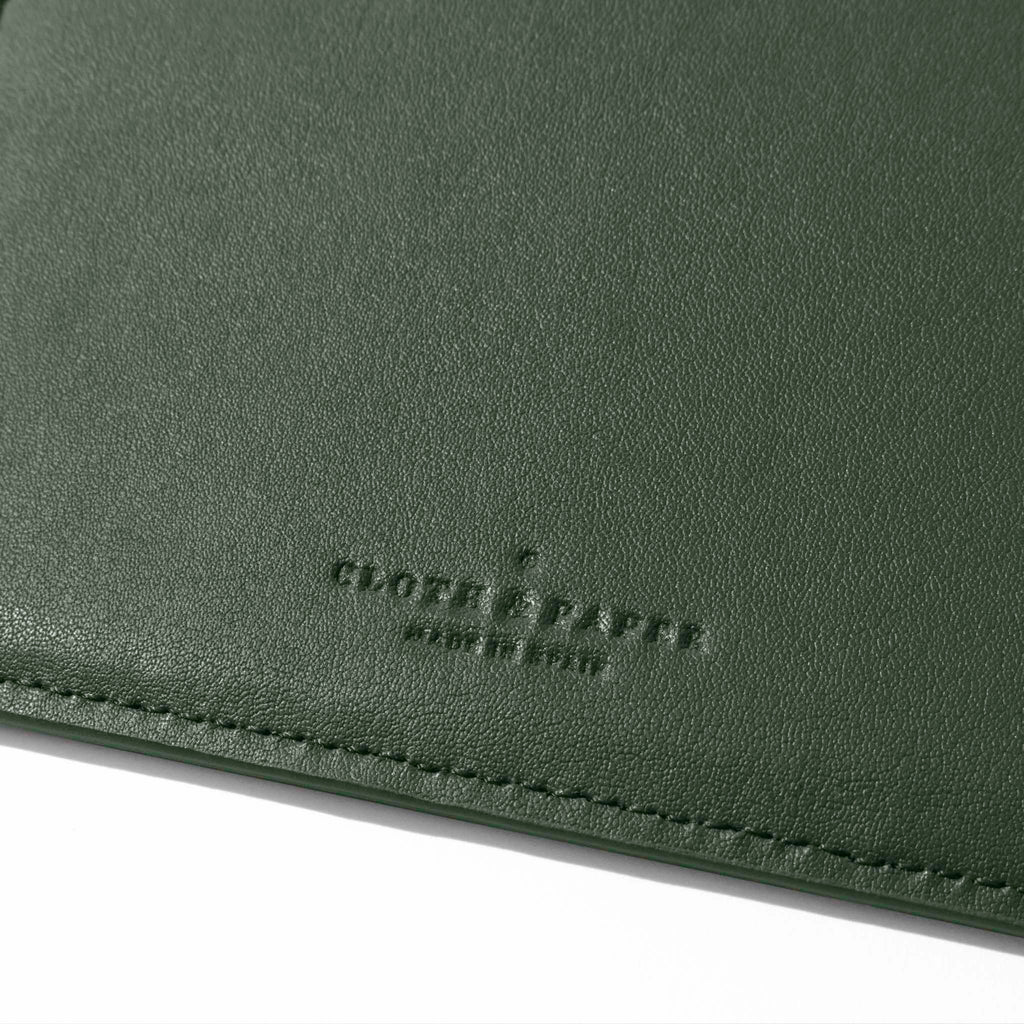 Closeup of valley green folio's textured vegan leather and stamped Cloth and Paper logo.