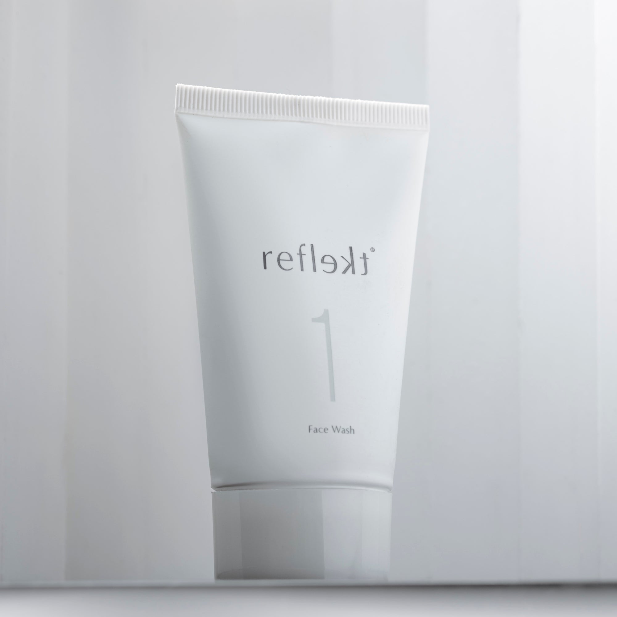 A container of Daily Exfoliating Face Wash by Reflect is standing up against a white background.