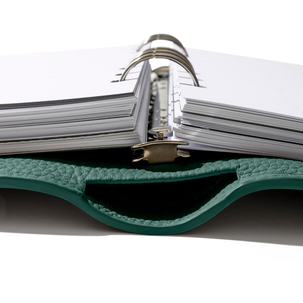 Closeup of agenda, showing its metal ring hardware and leather construction.