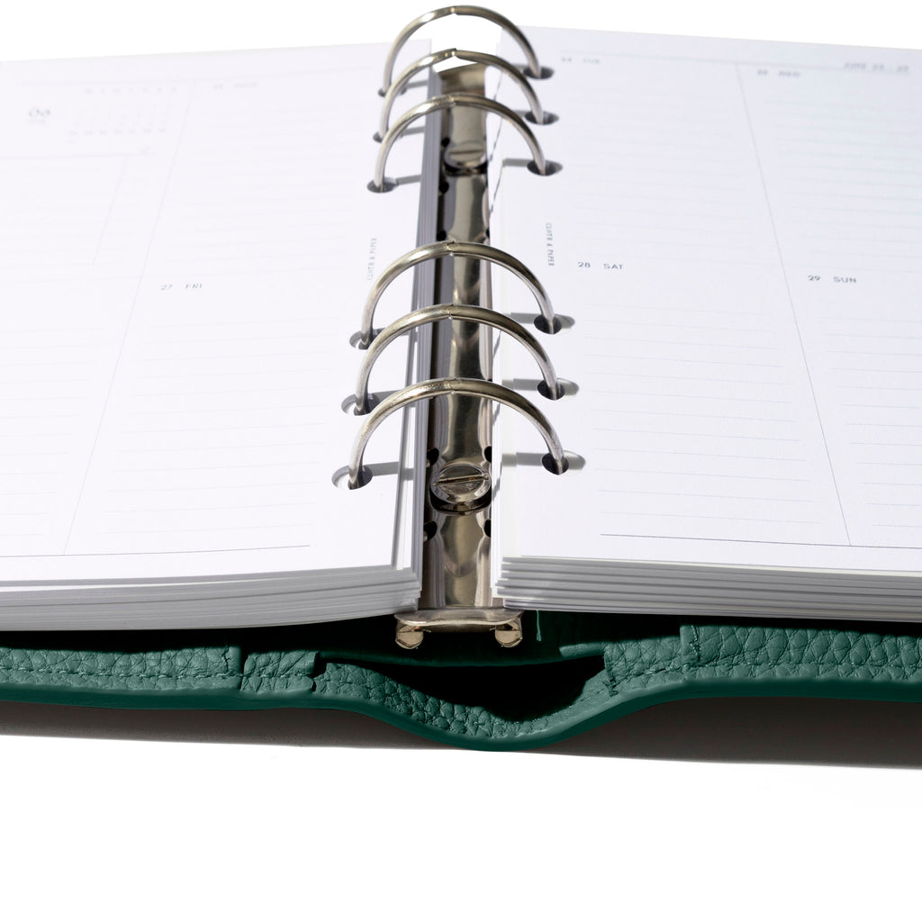 Closeup of agenda, showing its metal ring hardware and leather construction.