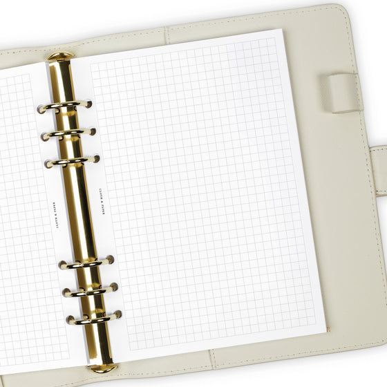 Close up of Graph Note planner inserts in use inside a white leather agenda.