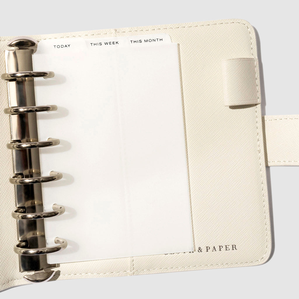 Pocket Black Foil Cadence Tab Dividers displayed in a white leather planner.