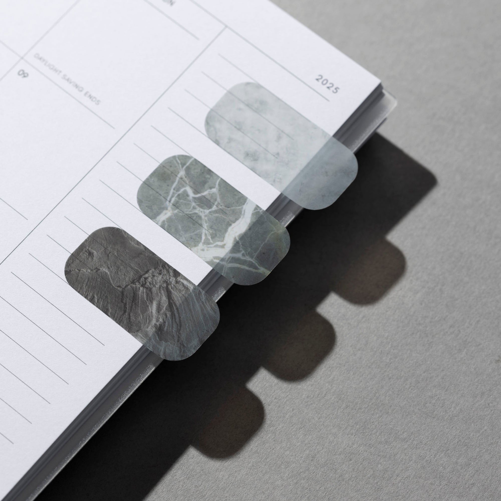 Luxe Page Flags in style Stone are in use on the side of a planner page.