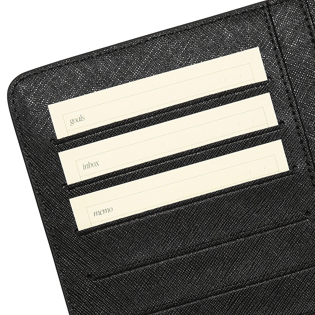Closeup of cards in use inside a black leather agenda.