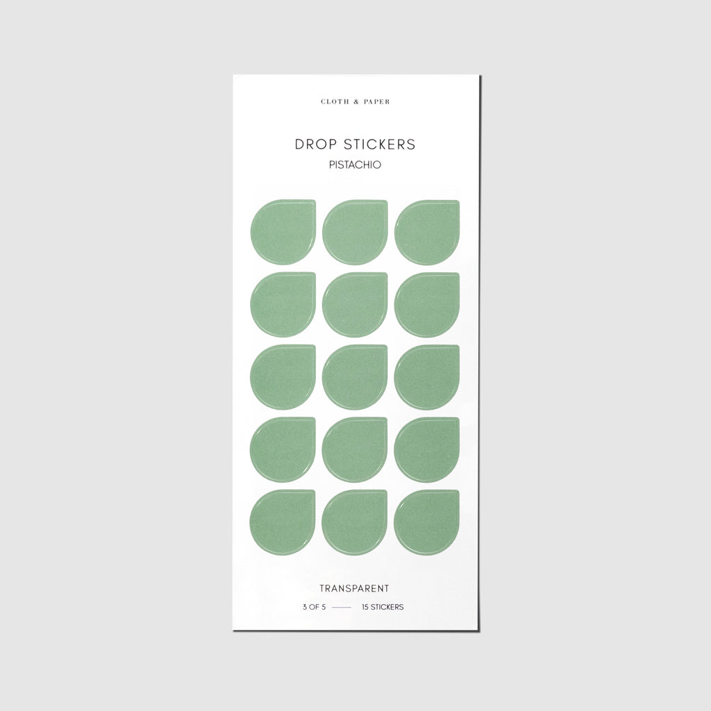 Minimal Shape Sticker Set, Transparent Drops, Pistachio, Cloth and Paper. Drop stickers in their packaging on a gray background.