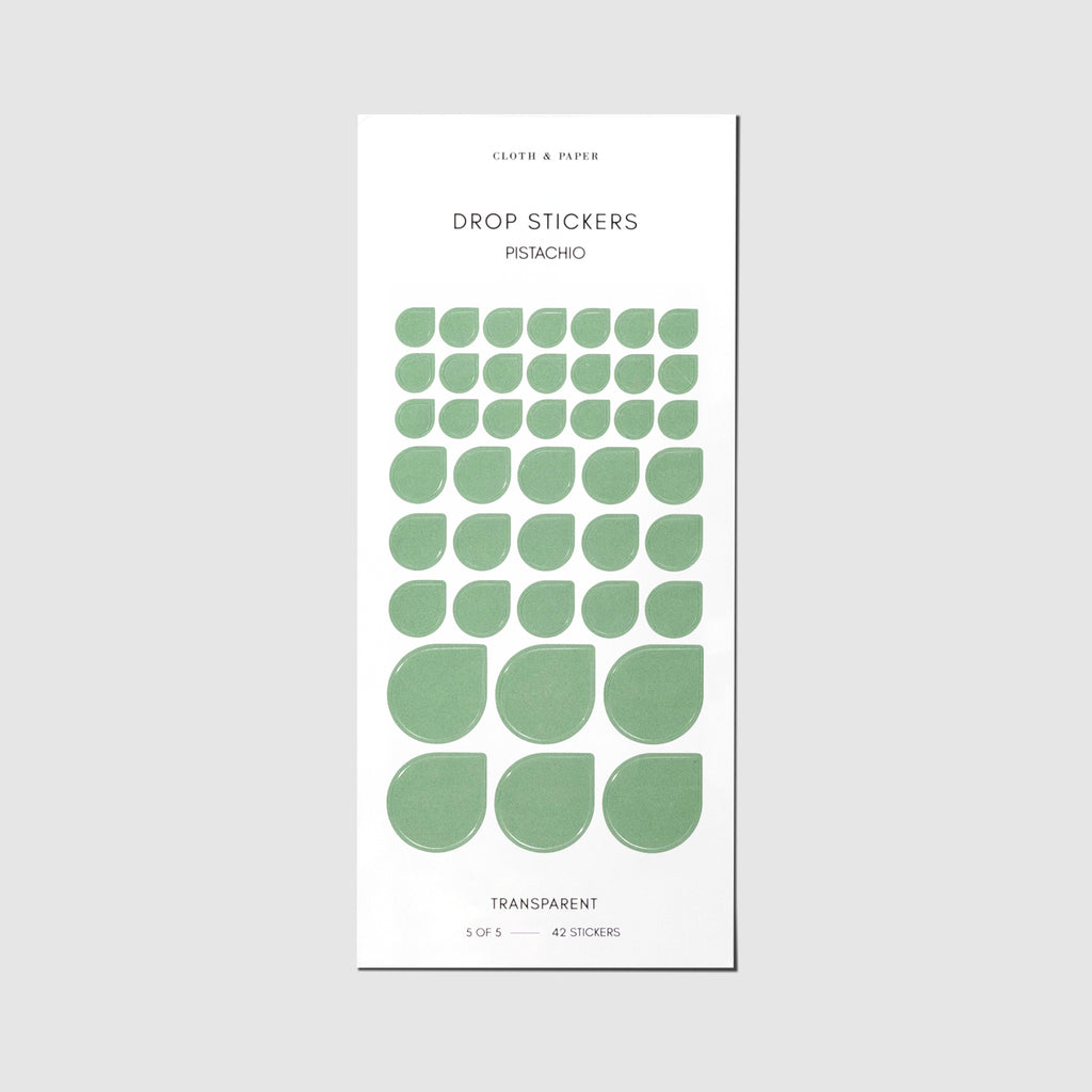 Minimal Shape Sticker Set, Transparent Drops, Pistachio, Cloth and Paper. Drop stickers in their packaging on a gray background.