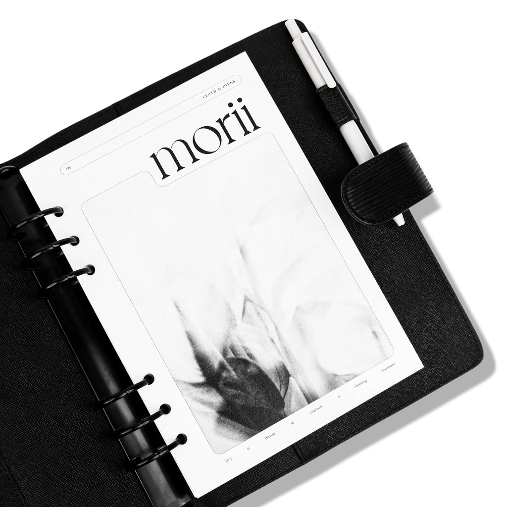 Morii Planner Dashboard, A5, Cloth and Paper. Dashboard in use inside of a black leather agenda. A white pen rests in the agenda's pen loop.