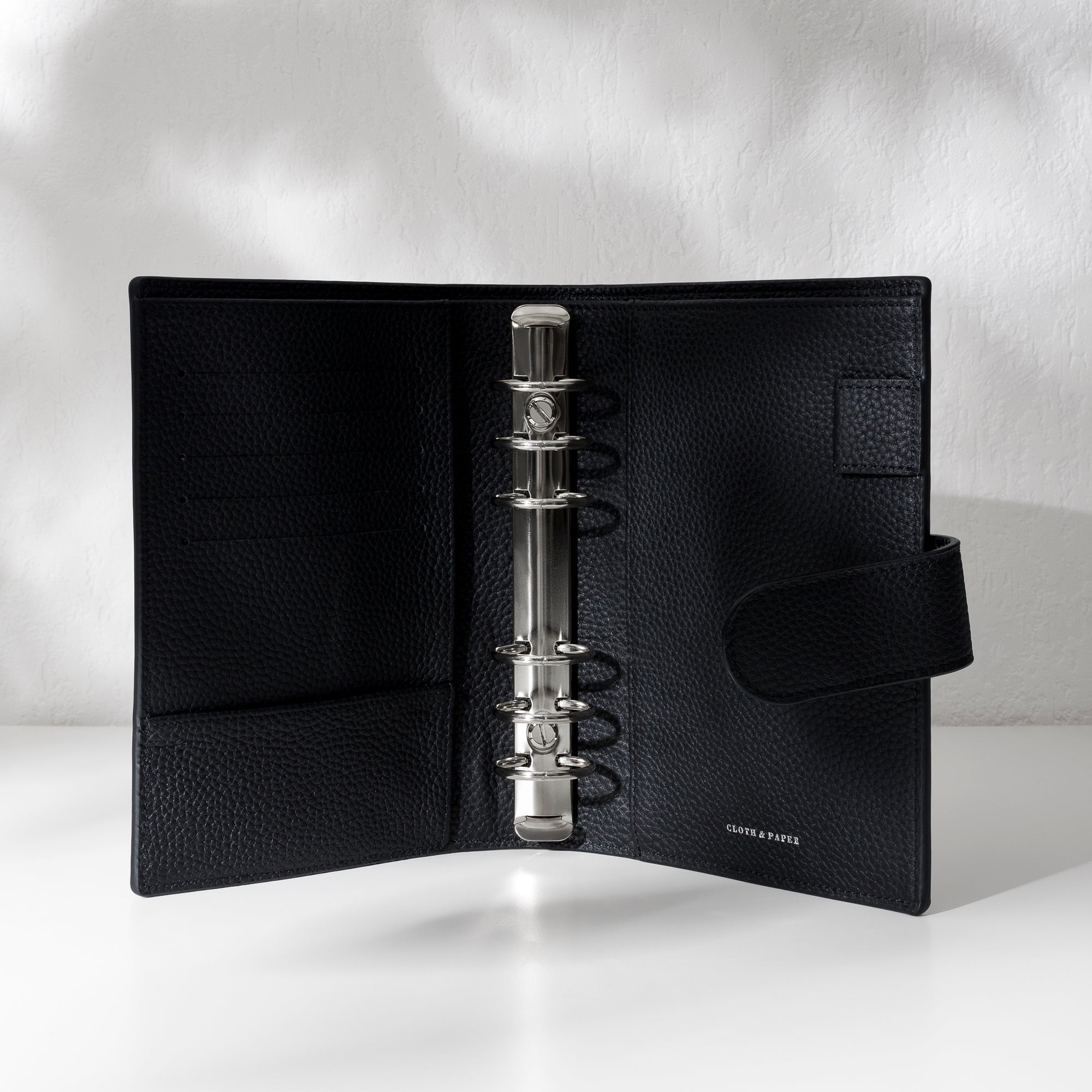 Closeup of silver hardware in a black leather agenda.