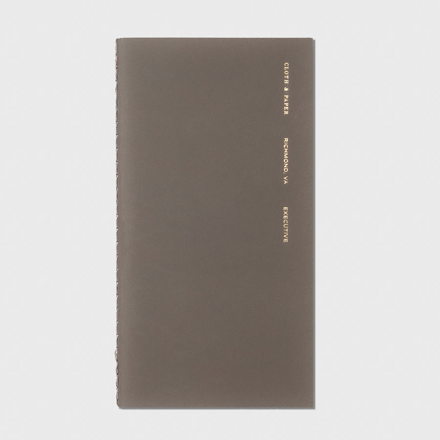 Overview image of the Cafe Noir Executive Pocket Plus notebook from the Traveler's Notebook Collection. The cover has gold foil text that reads Cloth and Paper Richmond, VA Executive and is displayed on a light gray background