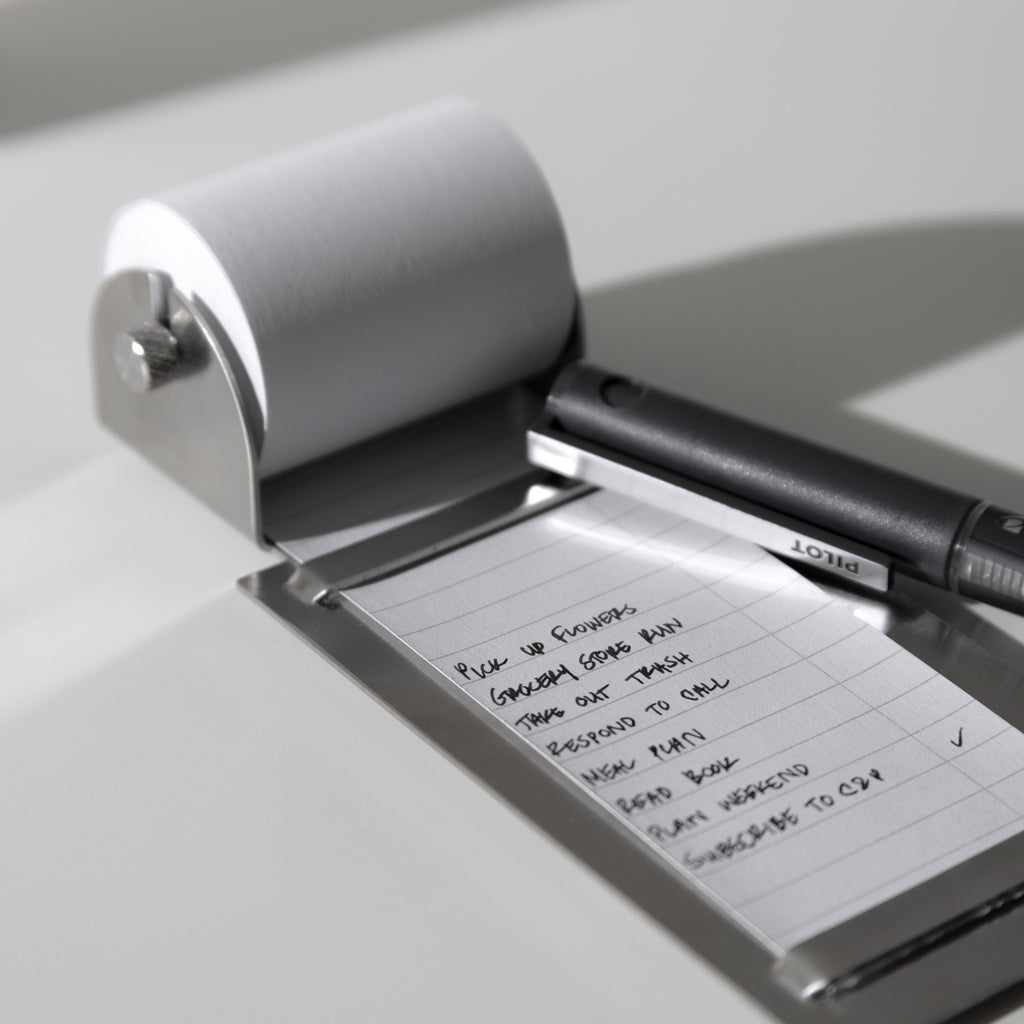 Task roller shown on a neutral background. A pen is shown resting on it, having filled out a task list.