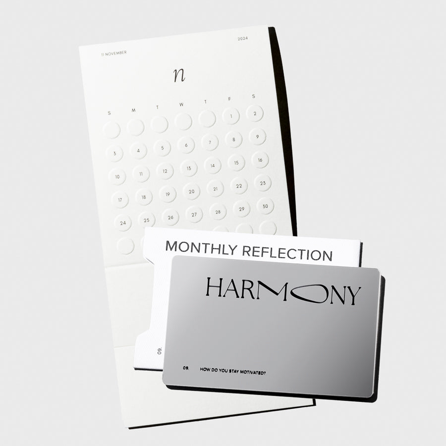 Image shows a silver, reflective journaling card placed on top of the monthly calendar card.