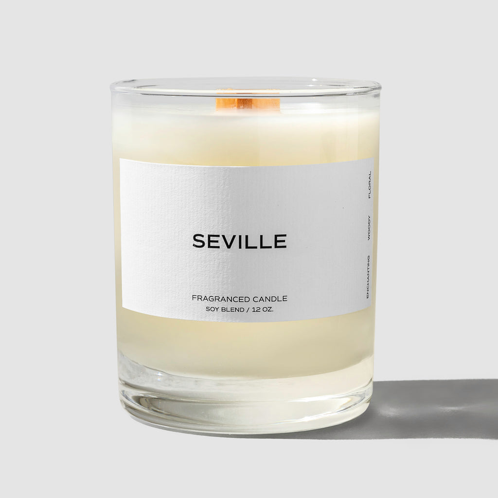 Seville Candle, Cloth and Paper. Candle displayed with its label facing the camera on a neutral background. Label reads "Seville" and the line below reads "Fragranced candle / Soy Blend / 12 oz"