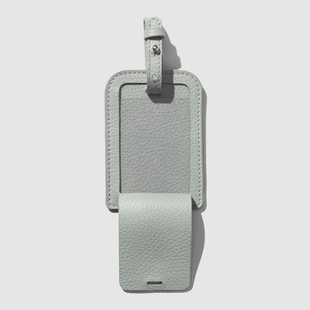 Luggage tag displayed on a neutral background. Its front flap is open to show the internal compartment.