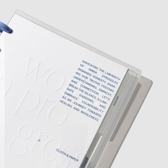 Closeup of dashboard inside journal. It is white, with embossed white and printed blue text accents.