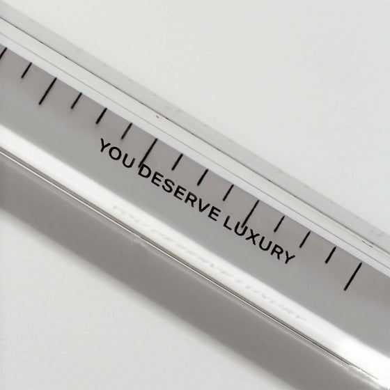 Close up of text on ruler that reads "YOU DESERVE LUXURY."