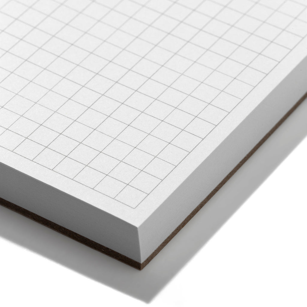 Closeup of the graph grid paper on the notepad.