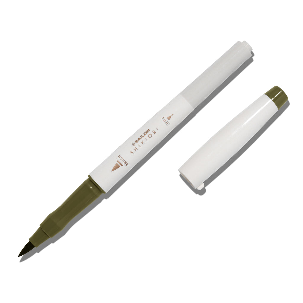 Brush pen displayed on a white background. It is uncapped with its brush nib exposed, and the cap lying parallel to the marker. Color pictured is Rikyucha. 