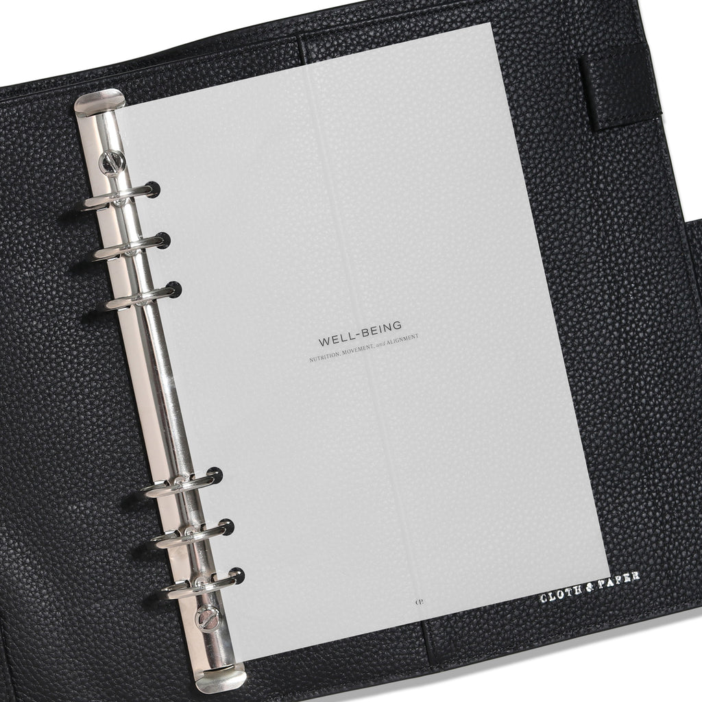 A5 dashboard displayed in a black leather planner. 